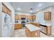 Eat-in kitchen with stainless appliances, tile flooring, wood cabinets and a center island for entertaining at 10332 George Hart Ct, Las Vegas, NV 89129