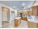 Well-lit kitchen boasts wood cabinets, tile floors, stainless appliances, and a convenient center island at 10332 George Hart Ct, Las Vegas, NV 89129