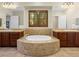 Bathroom featuring dual vanities, large mirrors, a jetted tub, and tile flooring at 11504 White Cliffs Ave, Las Vegas, NV 89138