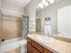 Well-lit bathroom featuring decorative wall tiles, a framed mirror, and a bathtub at 11504 White Cliffs Ave, Las Vegas, NV 89138