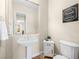 Charming half-bathroom features a pedestal sink, toilet, and decorative wall art at 11504 White Cliffs Ave, Las Vegas, NV 89138