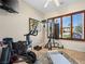 Bright workout area featuring a peloton bike, hardwood shutters, and tile floors at 11504 White Cliffs Ave, Las Vegas, NV 89138
