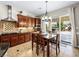 Bright kitchen area featuring wood cabinets, stone backsplash, stainless steel appliances, and an adjacent dining table at 11504 White Cliffs Ave, Las Vegas, NV 89138