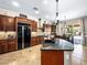 Spacious kitchen featuring dark wood cabinetry, granite countertops, and an island with a sink at 11504 White Cliffs Ave, Las Vegas, NV 89138