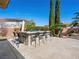 An outdoor kitchen and bar area provides ample seating, grill, sink, and stone accents overlooking the backyard at 11504 White Cliffs Ave, Las Vegas, NV 89138