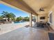 Covered patio space overlooking the pool with rock waterfall and outdoor lounge area at 11504 White Cliffs Ave, Las Vegas, NV 89138