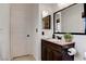 Bathroom with a dark vanity, large mirror, and a white door at 1584 Bermuda Dunes Dr, Boulder City, NV 89005