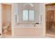 Bright bathroom featuring a soaking tub, window with shutters, and glass shower at 1584 Bermuda Dunes Dr, Boulder City, NV 89005