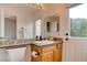 Full bathroom featuring granite countertop, wood vanity, and access door to outdoor space at 1584 Bermuda Dunes Dr, Boulder City, NV 89005