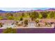 Exterior view featuring multi-car garage, grass, landscaping and mountain views at 1584 Bermuda Dunes Dr, Boulder City, NV 89005
