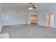 Open-concept living room with neutral carpet, ceiling fan, and access to other rooms at 1584 Bermuda Dunes Dr, Boulder City, NV 89005