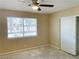Bedroom with large window, fan and light, baseboard and door to closet at 1681 Appaloosa Ln, Pahrump, NV 89060