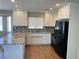 Bright kitchen featuring granite counters, white cabinetry, stainless appliances, and wood laminate floors at 1681 Appaloosa Ln, Pahrump, NV 89060