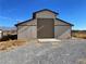 Outbuilding with roll-up door, ample space for storage and projects enhancing property's functionality at 1681 Appaloosa Ln, Pahrump, NV 89060