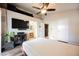 This bedroom features wood-look floors, a ceiling fan, tv, and access to laundry and bathroom at 204 Mchenry St, Las Vegas, NV 89144