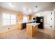 Bright kitchen featuring an island, wood cabinets, and modern black appliances on an easy-to-clean tile floor at 204 Mchenry St, Las Vegas, NV 89144