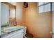 Stylish half bath features a marble countertop, vanity, and a decorative mirror at 2503 Kaymin Ridge Rd, Henderson, NV 89052