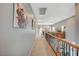Upstairs hallway featuring carpeted floors, artwork on the walls, and a wooden railing at 2503 Kaymin Ridge Rd, Henderson, NV 89052
