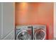 LG front load washer and dryer in the laundry area with orange accent wall at 2503 Kaymin Ridge Rd, Henderson, NV 89052