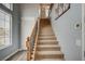 Inviting staircase with carpeted steps, a wooden banister, and natural light from a window at 2503 Kaymin Ridge Rd, Henderson, NV 89052