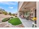 Inviting back patio featuring an artificial grass area, desert landscaping, and a charming covered seating area at 2535 Jada Dr, Henderson, NV 89044