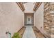 A home's entryway, with a pathway leading to a front door, flanked by rock accents and desert landscaping at 2535 Jada Dr, Henderson, NV 89044