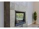 Close-up view of modern fireplace with stone surround and a decorative tree nearby at 2672 Mystere Ct, Las Vegas, NV 89117