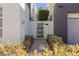 Modern home featuring a gated entrance, desert landscaping, and contemporary design elements at 2672 Mystere Ct, Las Vegas, NV 89117