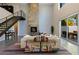 Cozy living room with fireplace, sleek staircase, and backyard access through sliding glass doors at 2672 Mystere Ct, Las Vegas, NV 89117