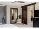 Neutral main bedroom with an accent chair, a dark barn door, and closet access at 2672 Mystere Ct, Las Vegas, NV 89117