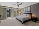 Light-filled main bedroom featuring access to balcony, light gray walls, and ceiling fan at 2672 Mystere Ct, Las Vegas, NV 89117