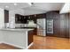 Modern kitchen featuring stainless steel appliances, dark cabinetry, and hardwood floors at 3012 Pier Harbor Dr, Las Vegas, NV 89117