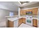 Bright kitchen with white appliances and adjacent to a living area at 3351 Indian Shadow St # 204, Las Vegas, NV 89129