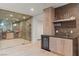 Stylish bar area with wine storage and beverage fridge with wood flooring at 3452 Spanish Winds Ct, Las Vegas, NV 89141