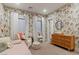 Charming bedroom with patterned wallpaper, a changing table, and white trim at 3452 Spanish Winds Ct, Las Vegas, NV 89141
