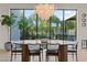Stylish dining area with large windows offering backyard views, next to a green plant at 3452 Spanish Winds Ct, Las Vegas, NV 89141