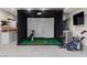 Home golf simulator with turf, screen, projector, and all the essentials for a fun game at 3452 Spanish Winds Ct, Las Vegas, NV 89141
