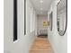 Modern hallway with hardwood floors, recessed lighting, and wall decor leading to an inviting living area at 3452 Spanish Winds Ct, Las Vegas, NV 89141
