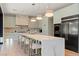Modern kitchen featuring a large island with seating, light green cabinetry and stainless steel appliances at 3452 Spanish Winds Ct, Las Vegas, NV 89141