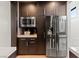 Dark wood cabinets, stainless steel appliances, microwave and fridge with counter space at 3452 Spanish Winds Ct, Las Vegas, NV 89141