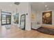 Bright entryway with wood floors, mirrors, art, and modern furnishings at 3452 Spanish Winds Ct, Las Vegas, NV 89141