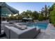 Inviting backyard pool with ample lounge seating, umbrellas, and lush landscaping at 3452 Spanish Winds Ct, Las Vegas, NV 89141