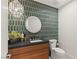 Stylish powder room featuring geometric tile accent wall, elegant mirror and modern vanity at 3452 Spanish Winds Ct, Las Vegas, NV 89141