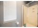 Bathroom featuring tiled shower with glass door, and window for natural light at 3717 Moonshine Falls Ave, North Las Vegas, NV 89085