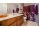 Bathroom features a dual-sink vanity with wood cabinets and a shower with purple curtain at 3717 Moonshine Falls Ave, North Las Vegas, NV 89085