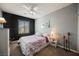 This bedroom has a black accent wall, light walls, a ceiling fan and a window at 3717 Moonshine Falls Ave, North Las Vegas, NV 89085