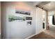 Hallway features artwork on a gray wall, a sliding barn door, and tile flooring in the bathroom at 3717 Moonshine Falls Ave, North Las Vegas, NV 89085