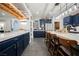 Large kitchen with a waterfall island, bar seating, modern lighting, and ample storage at 3717 Moonshine Falls Ave, North Las Vegas, NV 89085