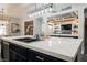 Kitchen island showcases marble countertop with seating and flows into open floor plan with a custom beverage center at 3717 Moonshine Falls Ave, North Las Vegas, NV 89085