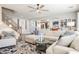 Spacious living room with staircase, cozy sofa, stylish rug, and views into the kitchen area at 3717 Moonshine Falls Ave, North Las Vegas, NV 89085